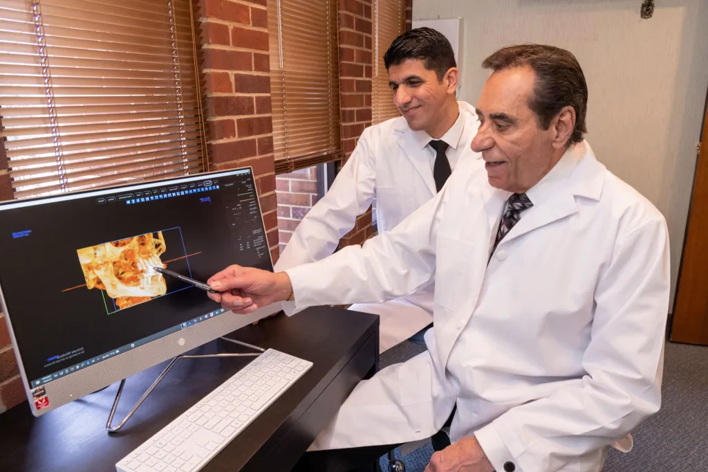 both oral surgeons looking at scans on computer