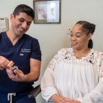 Dr. A showing patient a model of teeth